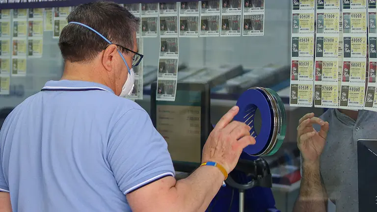Un hombre compra lotería en una Administración. EUROPA PRESS