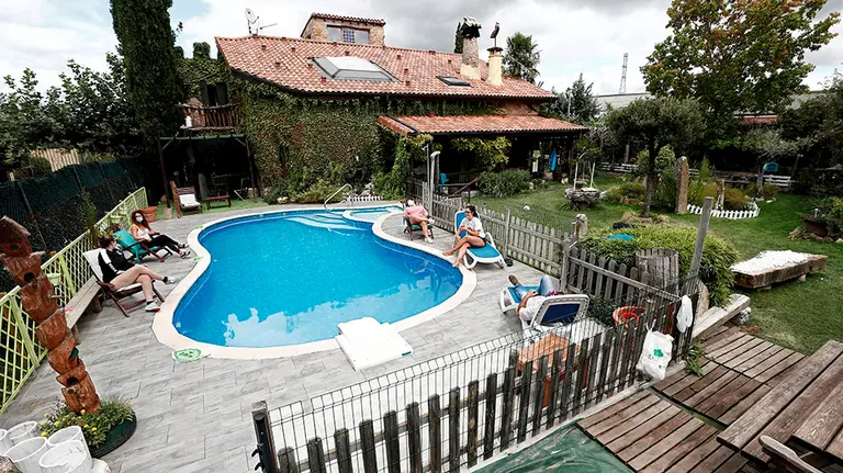 MUTILVA (NAVARRA), 30/08/2020.- Un grupo de mujeres de un equipo de fútbol de Navarra descansan junto a la piscina de la casa rural "Cuidando Te" construida en su totalidad con materiales respetuosos con el medio ambiente, como la piedra y la madera de la zona, situada en Mutilva, localidad a escasos kilómetros de Pamplona. Tras meses de incertidumbre y una paralización económica por la pandemia, los alojamientos de turismo rural han logrado cerrar un agosto "positivo" en ocupación, aunque el sector matiza que la situación ha sido "dispar", dependiendo de las prestaciones ofrecidas y de cada región.  EFE/Jesús Diges
