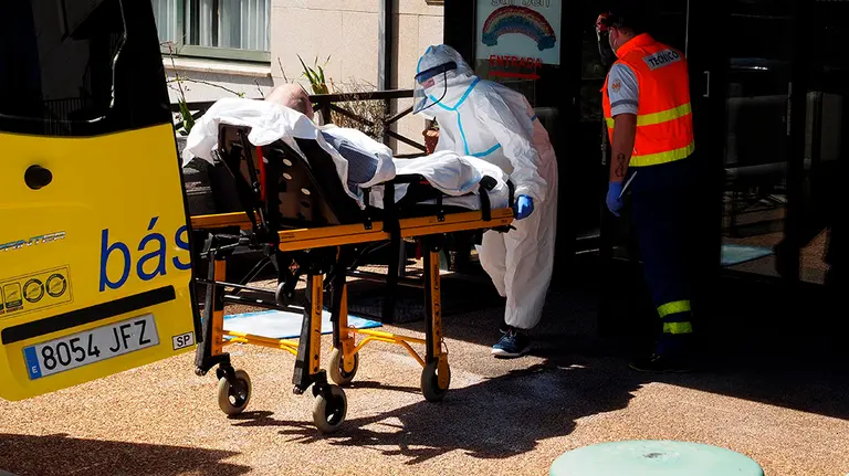 GRAF4404. O INCIO (LUGO), 22/08/2020.- Personal sanitario del HULA trasladan a un paciente a una ambulancia medicalizada desde la residencia de O Inicio (Lugo), donde ayer se registró un importante brote de covid-19. EFE/ Eliseo Trigo