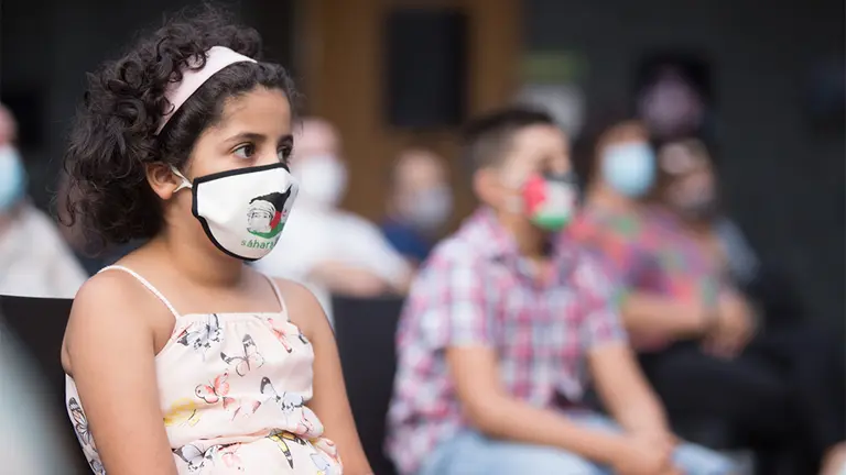 Una niña atiende en el Acto Institucional de bienvenida y reconocimiento a las familias de acogida de los niños y niñas saharauis. PARLAMENTO DE NAVARRA