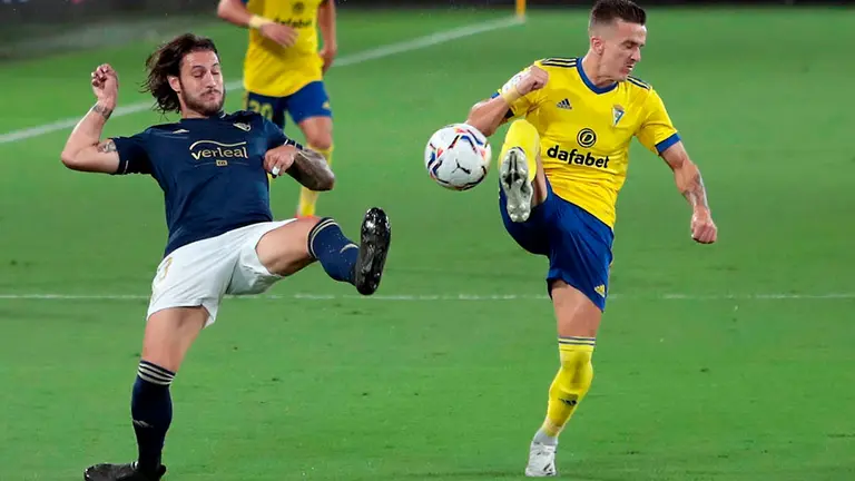 El defensa del Club Atlético Osasuna, Juan Cruz lucha por el balón con el delantero del Cádiz CF, Salvi Sánchez, , durante el partido de la primera jornada de Liga que enfrenta al Cádiz CF y al Osasuna en el estadio Ramón de Carranza. EFE/Román Ríos.