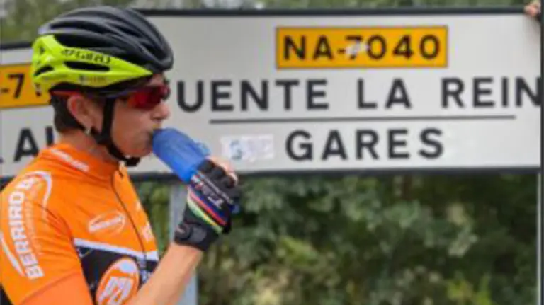 Sonia Elósegui bebiendo agua frente a un cartel en el que se lee &#39;Puente la Reina-Gares&#39;. FACEBOOK