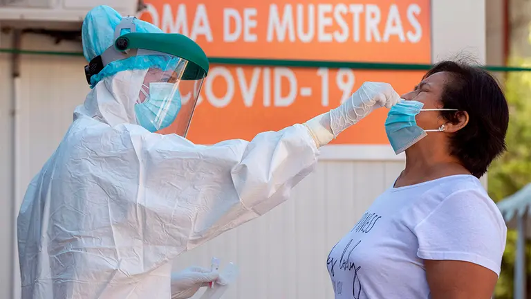 Una enfermera toma una muestras para una prueba PCR a una mujer. EFE/Marcial Guillén