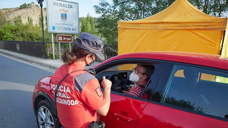 Un policía foral pide la documentación a un vehículo que circula por la carretera de entrada a la localidad de Peralta, Navarra (España) a 24 de septiembre de 2020. En este municipio navarro, a partir de hoy jueves 24, ha entrado en vigor la prohibición de entrar y salir salvo para desplazamientos imprescindibles, como medida para contener el incremento de casos de Covid-19, que se sitúan en una tasa de 1.700 casos por 100.000 habitantes.
24 SEPTIEMBRE 2020;COVID;PERALTA;CORONAVIRUS;NAVARRA;
Eduardo Sanz / Europa Press
24/9/2020