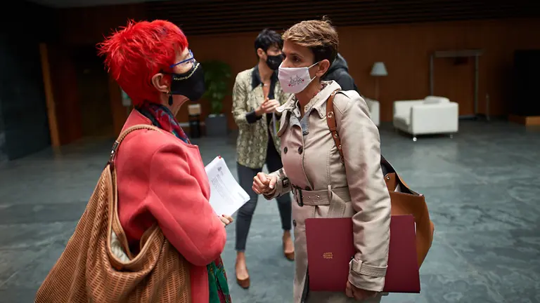 La presidenta del gobierno de Navarra, María Chivite, habla con la consejera de salud, Santos Indurain, durante el pleno parlamentario. MIGUEL OSÉS