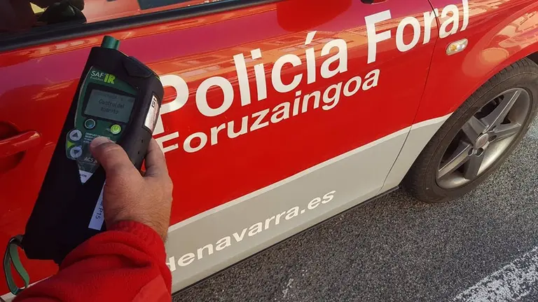 Un agente de la Policía Foral junto a su vehículo para hacer un control de alcoholemia. - POLICÍA FORAL