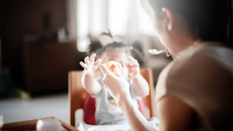Una madre dando de comer a su hija. ARCHIVO