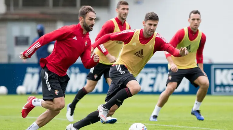 Adrián López conduce el balón ante Raúl Navas en Tajonar. CA Osasuna.