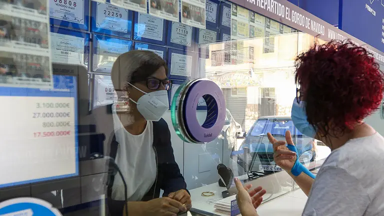 Una lotera de una Administración atiende a una clienta. 
Iván Terrón / Europa Press