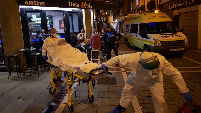 Una señora con coronavirus es trasladada en ambulancia por los sanitarios la noche en la que se cierra la hostelería debido a la segunda ola de la pandemia. MIGUEL OSÉS