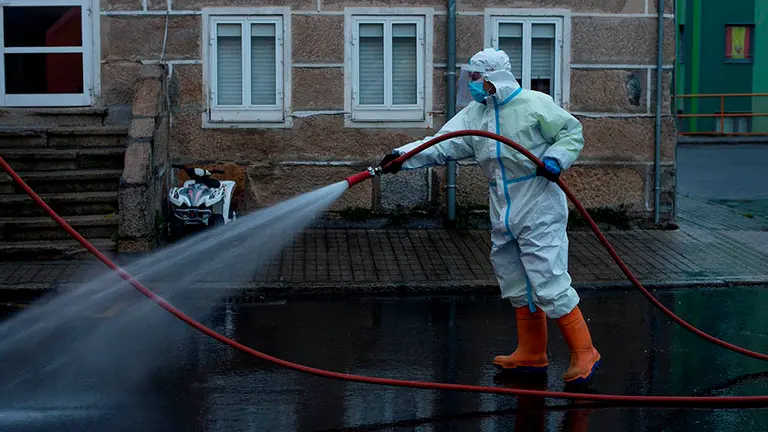 Un operario municipal realiza labores de desinfección a primera hora de este viernes en la ciudad de Orense. Galicia ha batido el récord de casos activos de covid-19 de la primera ola, al superar, con los 5.675 registrados a las seis de la tarde del pasado miércoles, los 5.481 del 8 de abril. EFE/ Brais Lorenzo
