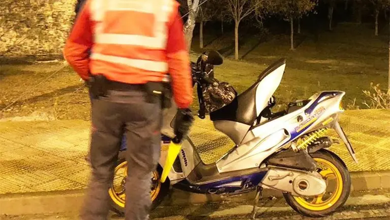 Un agente de la Policía Foral junto a la moto en la que circulaba el detenido. CEDIDA