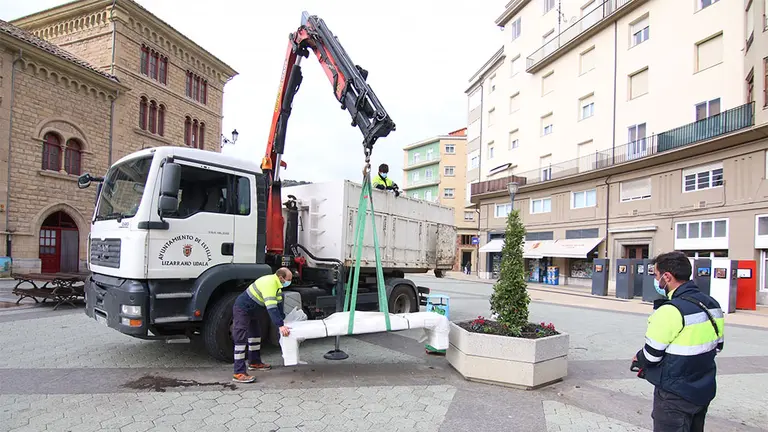 Varios operarios instalan los nuevos bancos de hormigón en la plaza de la Coronación de Estella. CEDIDA