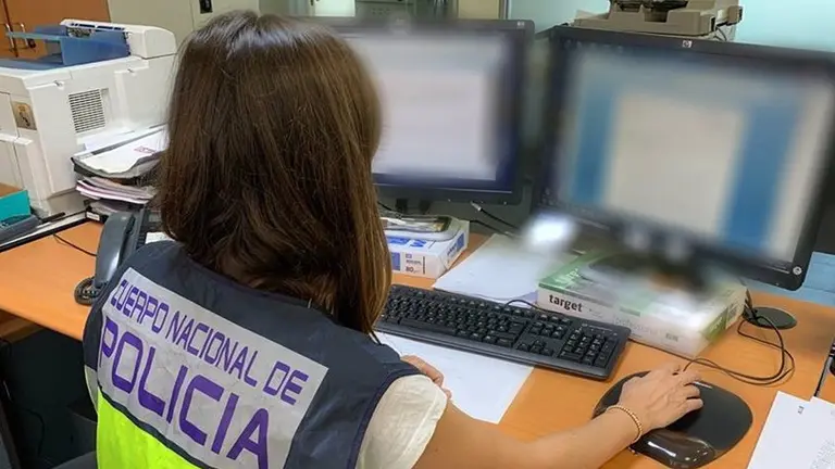 Una agente de policía delante de un ordenador. POLICÍA NACIONAL
