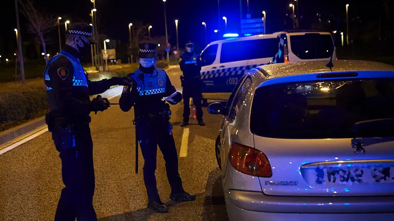 La Policía Municipal de Pamplona controla los coches que circulan por la ciudad durante el toque de queda, la mayoría van o salen de trabajar. PABLO LASAOSA