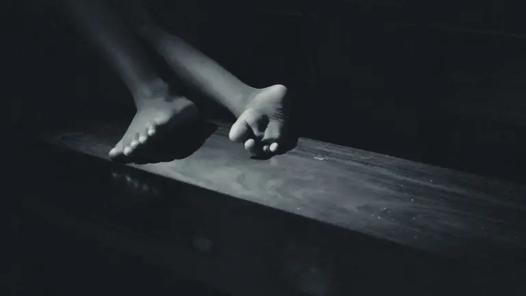 Un niño tumbado sobre un banco ARCHIVO