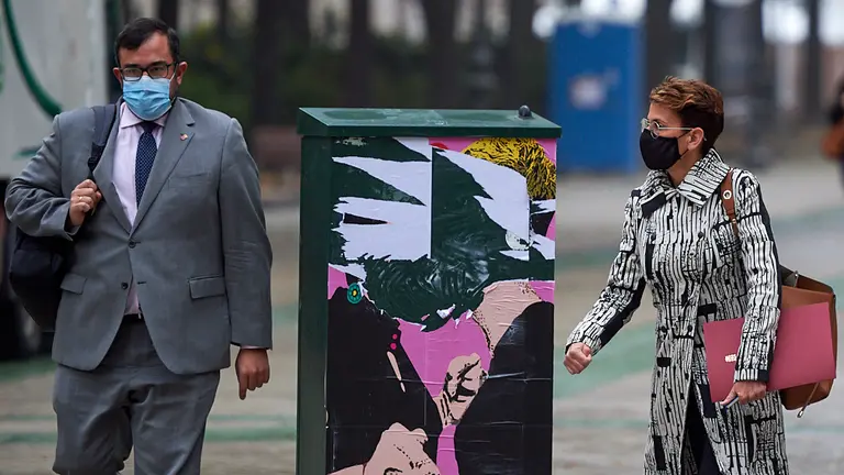 La Presidenta del Gobierno de Navarra, María Chivite, pasa por delante de la pintada del artista LKN frente al Parlamento Foral. MIGUEL OSÉS
