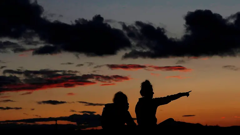 People are silhouetted against a orange colored sky at sunset in Ripagaina, near Pamplona, Spain, 10 November 2020. EFE/ Jesús Diges
