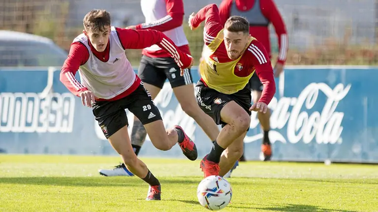 Kike Barja y Aimar Oroz luchan por un balón durante un entrenamiento en Tajonar OSASUNA