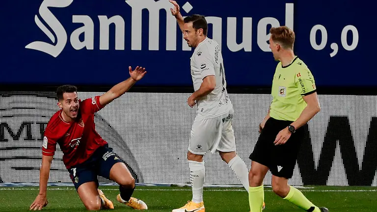 El delantero de Osasuna, Jonathan Rodriguez (i), protesta una jugada al colegiado Pizarro Gómez, durante el encuentro correspondiente a la jornada 10 de primera división que disputan esta noche frente al Huesca en el Estadio de El Sadar, en Pamplona. EFE/Jesús Diges.