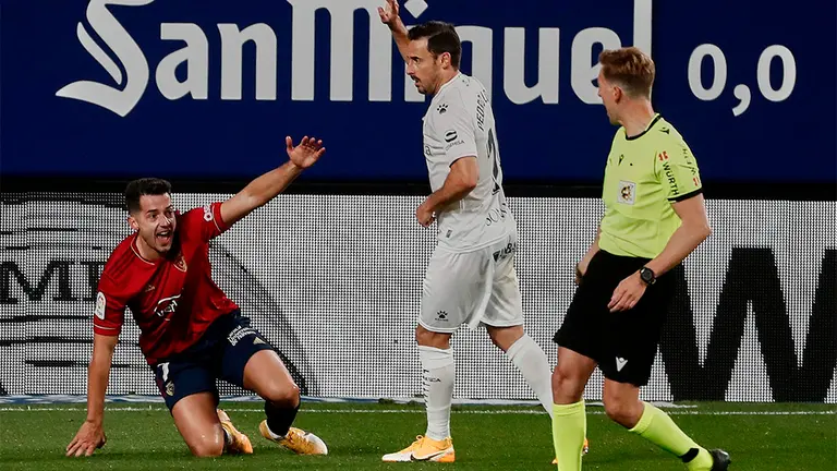 El delantero de Osasuna, Jonathan Rodriguez (i), protesta una jugada al colegiado Pizarro Gómez, durante el encuentro correspondiente a la jornada 10 de primera división frente al Huesca en el Estadio de El Sadar, en Pamplona. EFE/Jesús Diges.