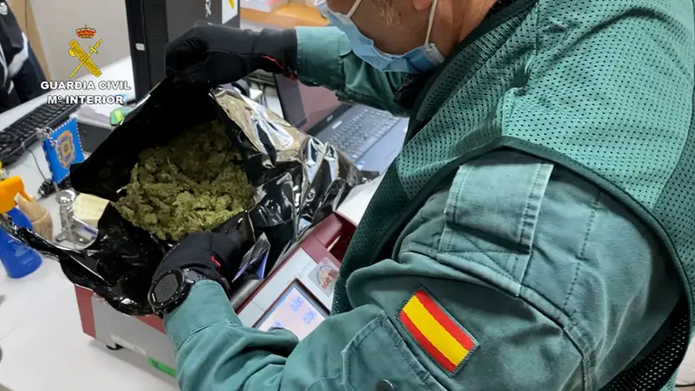 Un agente de la Guardia Civil pesa una de las bolsas halladas en el interior de un vehículo en Navarra. GUARDIA CIVIL