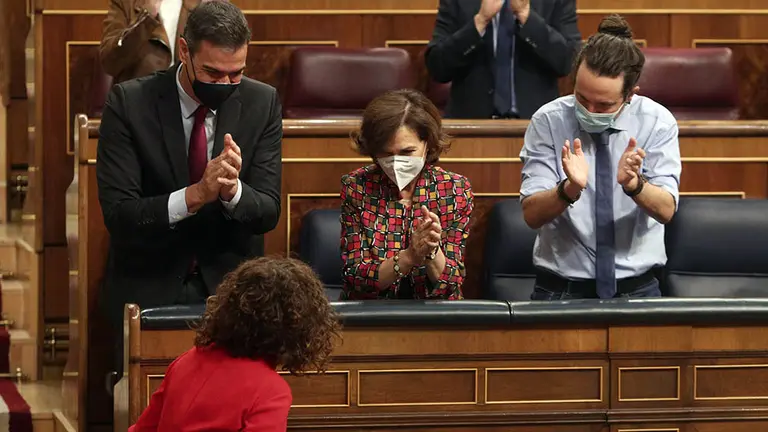 El presidente del Gobierno, Pedro Sánchez; la vicepresidenta primera y ministra de la Presidencia, Relaciones con las Cortes y Memoria Democrática, Carmen Calvo; y el vicepresidente de Derechos Sociales y Agenda 2030, Pablo Iglesias; aplauden a la ministra de portavoz y de Hacienda, María Jesús Montero.