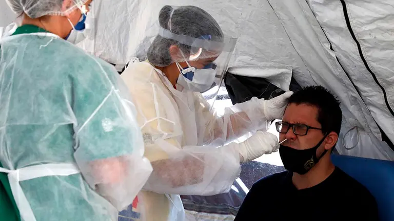 Personal médico le hace la prueba PCR de coronavirus a un hombre. EFE/ Fabio Motta