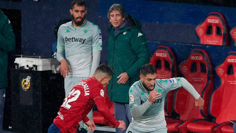 El delantero francés del Betis Nabil Fekir (d) pelea un balón con el defensa argentino de Osasuna Facundo Roncaglia durante el partido disputado entre ambos equipos esta tarde en el Estadio de El Sadar correspondiente a la décimo segunda jornada de la Liga Santander. EFE/Jesús Diges