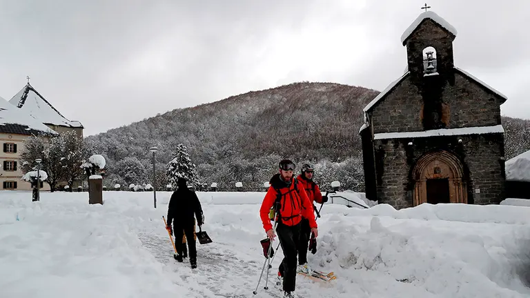 Dos esquiadores disfrutan de la nieve acumulada hasta este martes festivo en la localidad navarra de Roncesvalles tras el primer temporal de nieve y frío que azota estos días el centro y norte de la comunidad Foral. Navarra mantiene dos puertos de montaña cerrados al tráfico por la nieve, que obliga a circular con cadenas por otros tres tramos de vías, todas ellas secundarias de la red de la Comunidad foral. EFE/Villar López