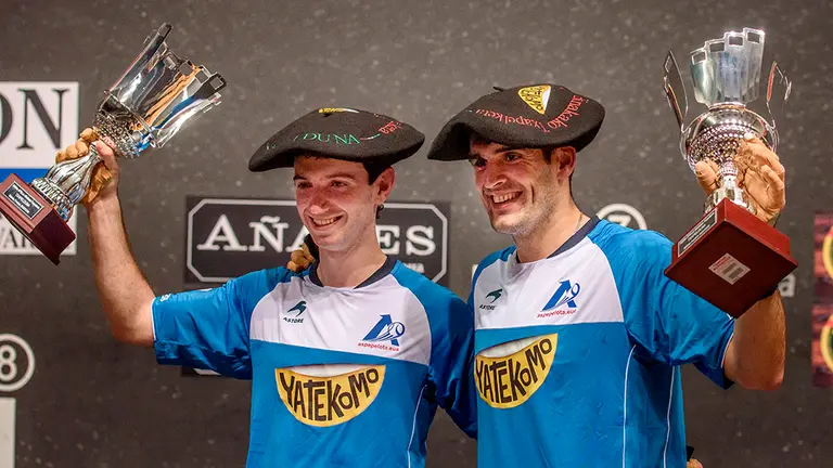 Los navarros Joseba Ezkurdia (d) y Julen Martija (i) celebran el triunfo con la copa y la txapela de campeones ante Aimar Olaizola y el vizcaíno Mikel Urrutikoetxea, tras la final del Campeonato de Parejas disputada este martes en Bilbao, una de las tres finales del año de pelota mano, la especialidad reina de la Pelota Vasca. EFE/JAVIER ZORRILLA