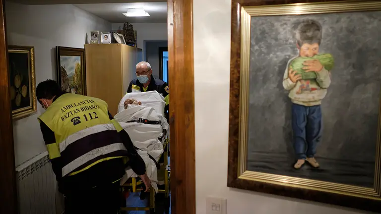 Javier Lion (i) y Carlos Marco, Técnicos en Emergencias Sanitarias, sacan del domicilio a un paciente para trasladarlo al hospital de Estella. MIGUEL OSÉS