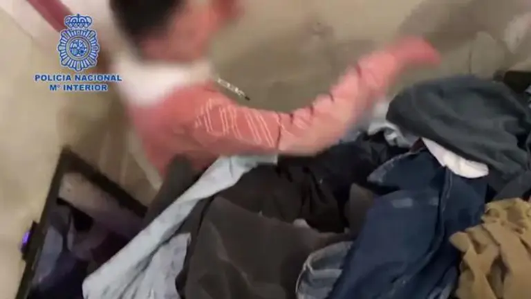 Una persona saliendo del zulo de una empresa textil en Murcia. POLICÍA NACIONAL