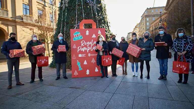 El alcalde, Enrique Maya, la gerente de la asociación de Comerciantes de Navarra, Inma Elcano, y representantes de distintas asociaciones de comerciantes presentan la campaña 'Regala Pamplona'. MIGUEL OSÉS