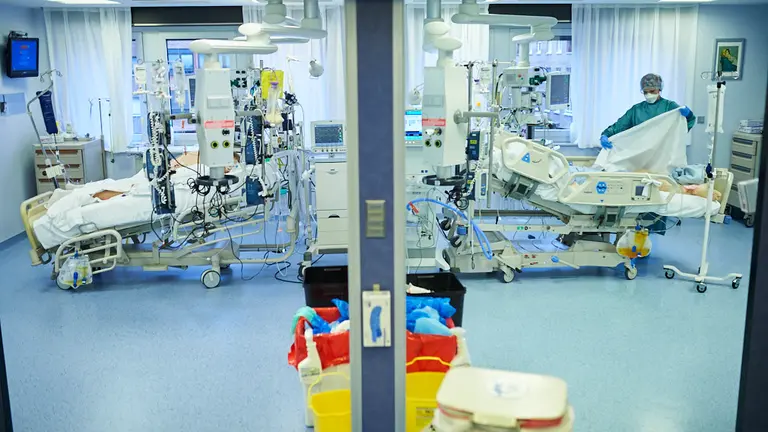 Una enfermera junto a un enfermo de coronavirus en la UCI de la CUN. PABLO LASAOSA