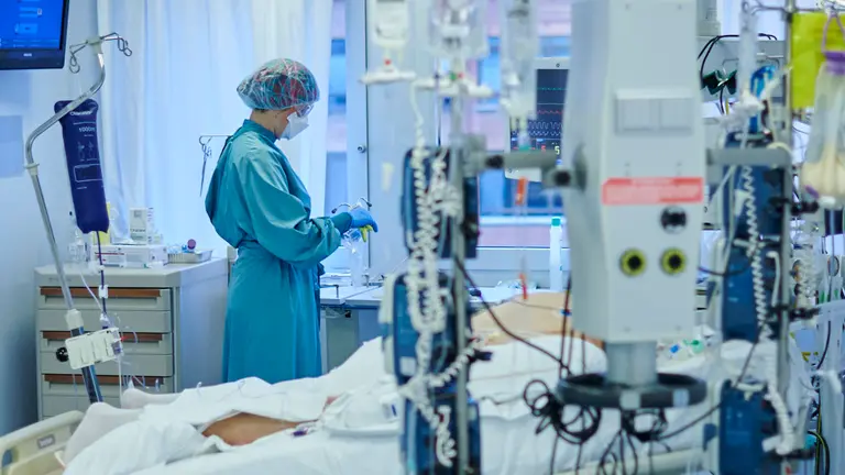 Una enfermera atiende a un paciente con coronavirus en la UCI de la CUN. PABLO LASAOSA