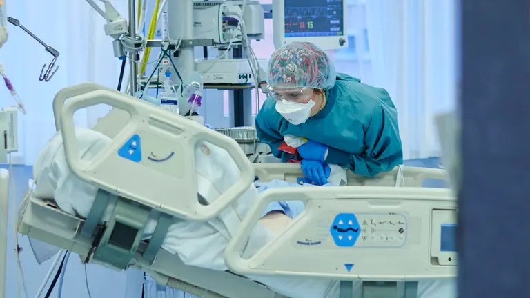 Una enfermera atiende a un paciente con coronavirus en la UCI de la CUN. PABLO LASAOSA