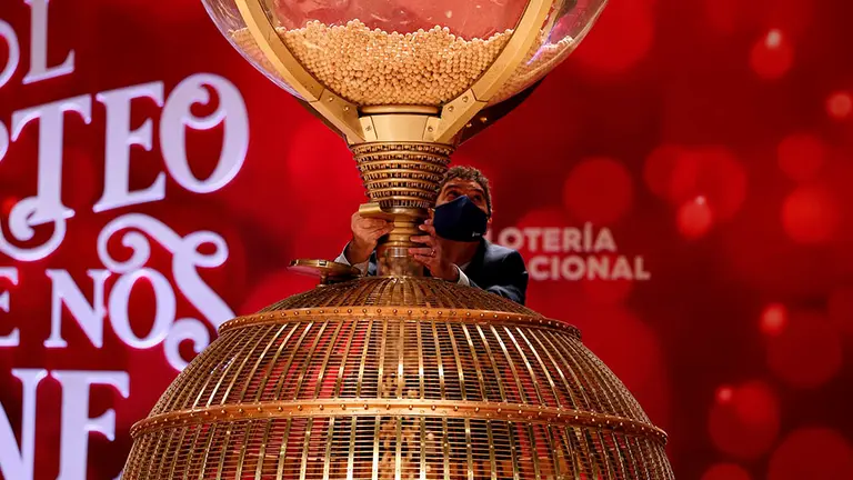 Personal de Loterías y Apuestas del Estado realiza el volcado de las bolas en el bombo antes del inicio del Sorteo Extraordinario de la Lotería de Navidad. EFE/J.J. Guillén