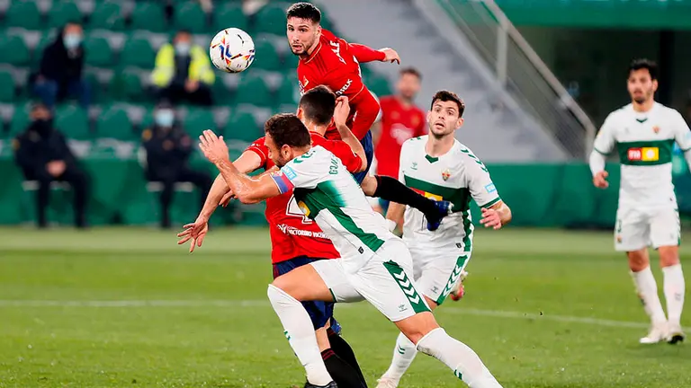 El jugador de Osasuna Jonathan Calleri (arriba), remata durante el partido contra el Elche, encuentro de la jornada 15 de LaLiga Santander que se disputa en el estadio Manuel Martínez Valero.- EFE/ Ramón