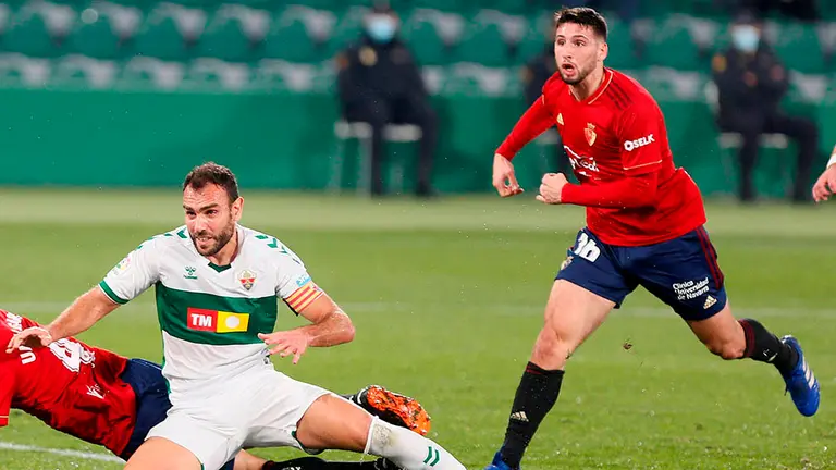 El jugador de Osasuna Jonathan Calleri (d), y el portero del Elche Edgar Badia, durante el partido de la jornada 15 de LaLiga Santander que se disputa en el estadio Manuel Martínez Valero.- EFE/ Ramón