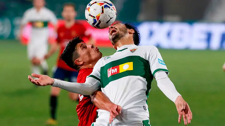 El defensa del Elche Juan Sánchez Miño (d) intenta controlar ante el defensa argentino de Osasuna Facu Roncaglia durante el partido de LaLiga celebrado este martes en el estadio Martínez Valero. EFE / Ramón