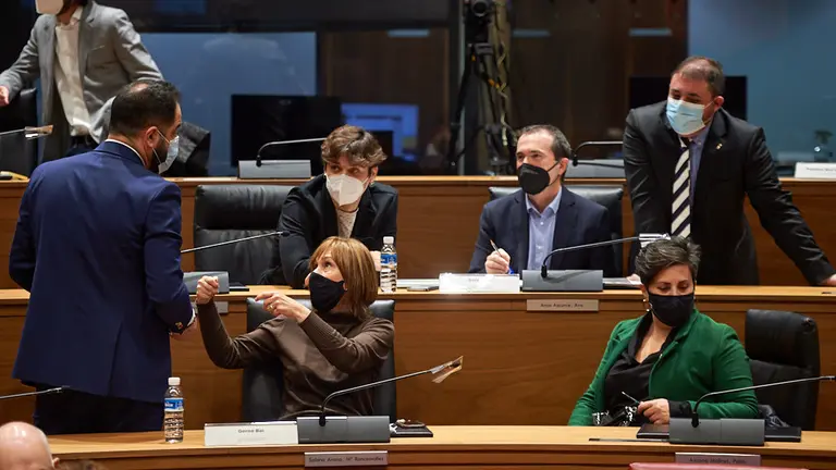 Ramón Alzorriz, portavoz del PSN, habla con el grupo parlamentario de Geroa Bai, durante el pleno del parlamento de Navarra. MIGUEL OSÉS