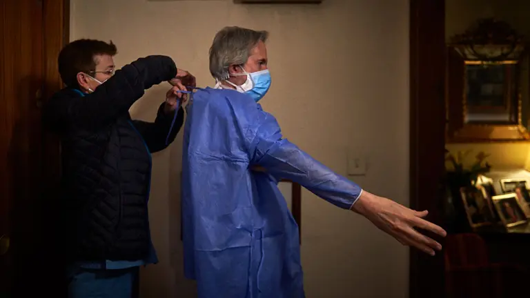 La enfermera ayuda al médico a ponerse el traje EPI (equipo de protección individual) momentos previos a acceder al domicilio del paciente. MIGUEL OSÉS