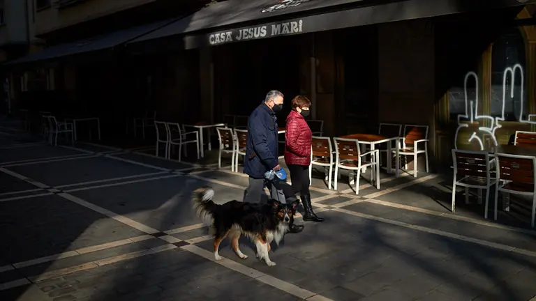Dos personas pasean con su perro por las calles del casco viejo de Pamplona durante la tercera ola del coronavirus en la Comunidad Foral. MIGUEL OSÉS