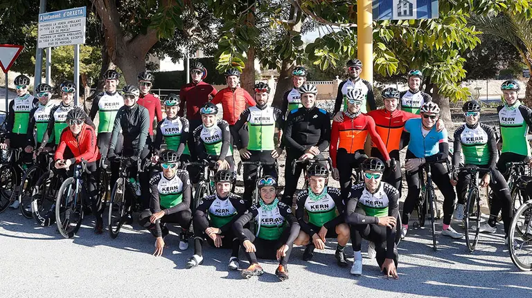 Miguel Induráin, Pedro Delgado y David Bisbal posan con los corredores del equipo mavarro en Vilajoiosa. Kern Pharma.