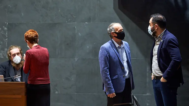 Ramón Alzorriz (d), portavoz del PSN, habla con Adolfo Araiz (i), miembro de EH Bildu, durante el pleno en el Parlamento de Navarra. MIGUEL OSÉS