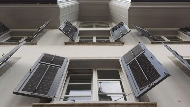 La fachada de un edificio con varias contraventanas abiertas ARCHIVO