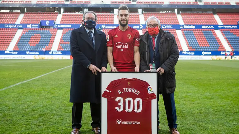 Roberto Torres posa con un cuadro con la camiseta conmemorativa de sus 300 partidos como rojillo. CA Osasuna.