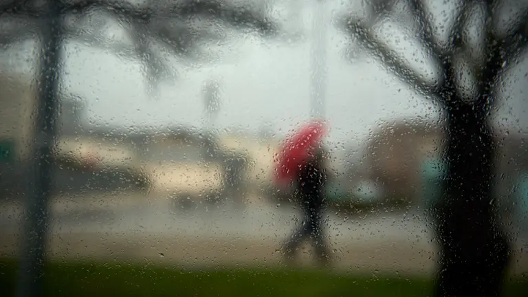 Una persona camina por las calles de Pamplona en un dia de lluvia durante la tercera ola del coronavirus en la Comunidad Foral. MIGUEL OSÉS