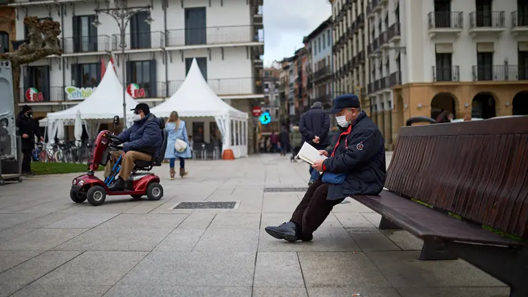 Un señor lee sentado en un banco de la Plaza del Castillo de Pamplona durante la tercera ola del coronavirus. MIGUEL OSÉS